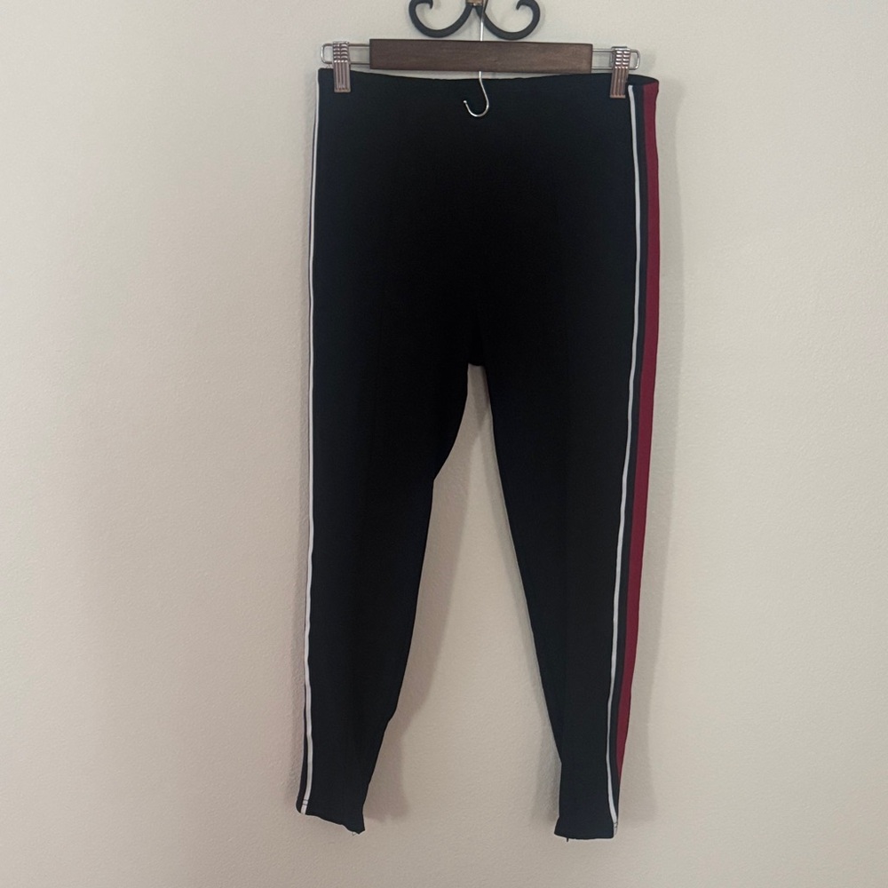 Woman’s Black smart Leggings with Red & White Side Stripe. Zip at ankles.